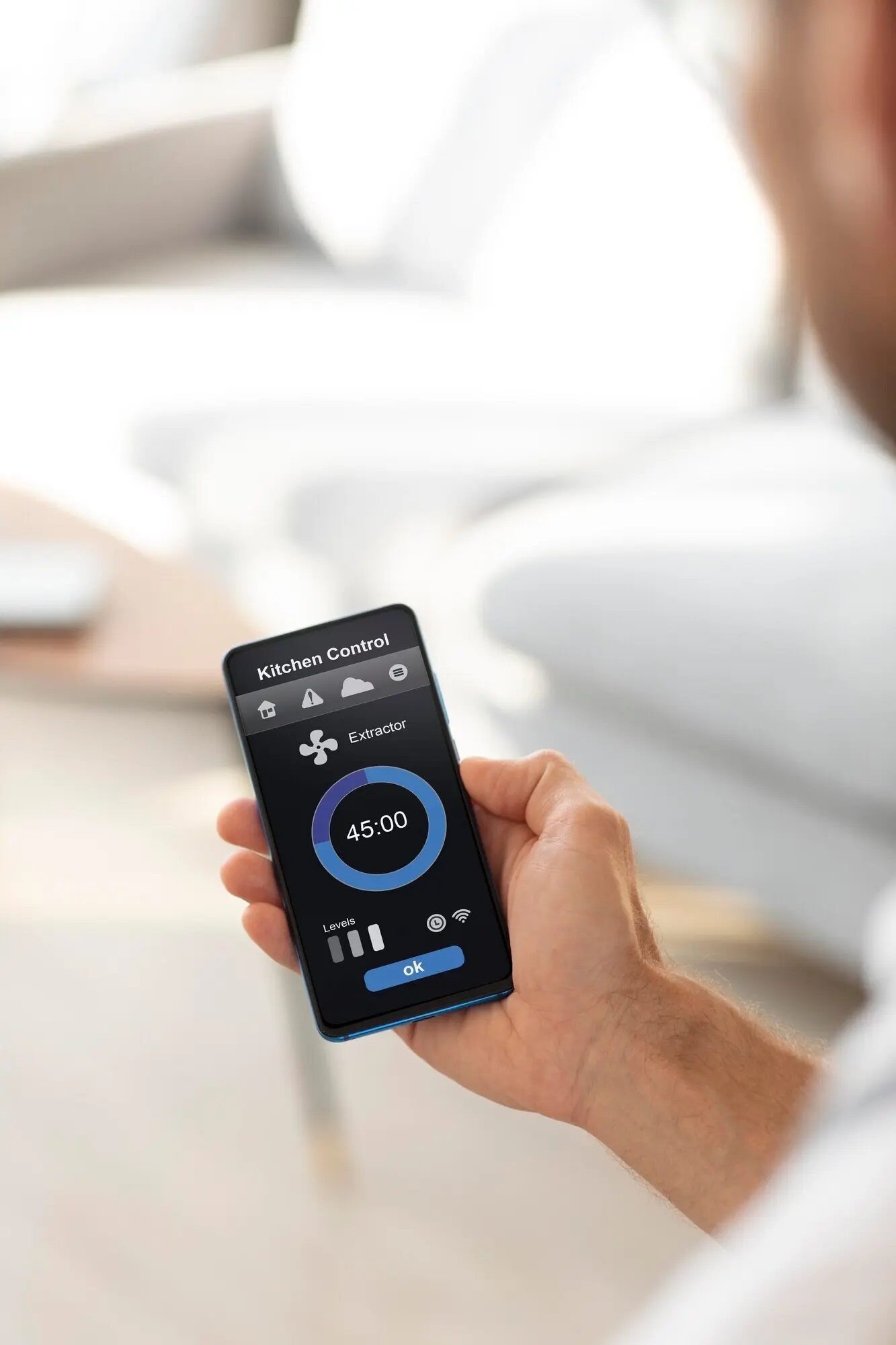 Mann hält ein Smartphone mit einer Smart-Home-App.